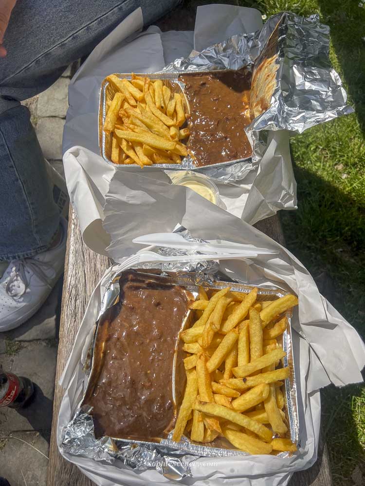 Traditional Belgian fries served in Brussels with dipping sauces, featuring crispy golden fries in a classic street food setting.