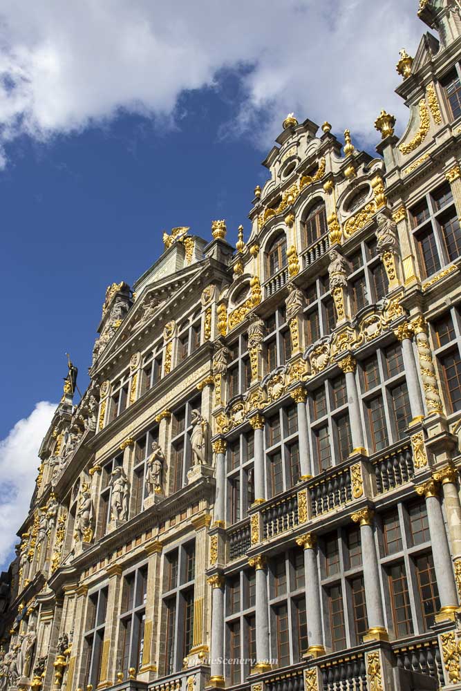 Historic buildings at grand place in Brussels Belgium with ornate gold details and blue sky