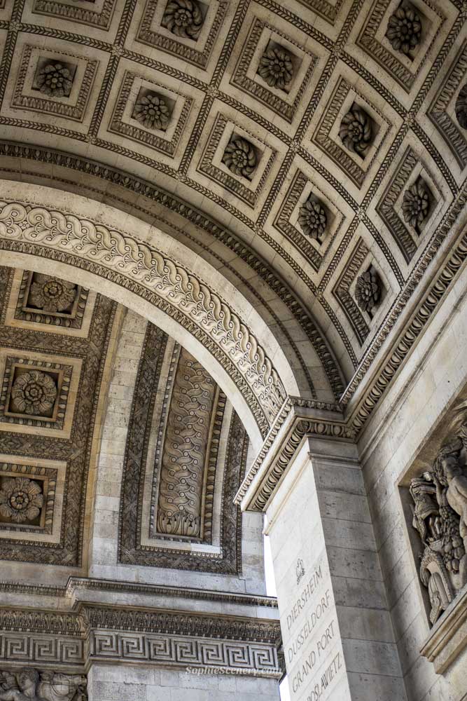 Close-up view of the Arc de Triomphe in Paris, showcasing the intricate stone carvings, detailed sculptures, and historic architectural features of the monument.
